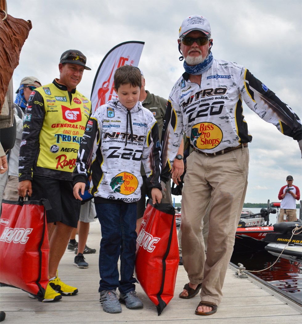 rick-clunn-river-clunn-skeet-reese-carry-ricks-bags-to-stage